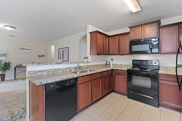 kitchen with light stone counters, light tile patterned flooring, a sink, a peninsula, and black appliances