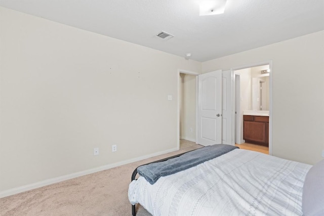 bedroom with light carpet, ensuite bath, visible vents, and baseboards