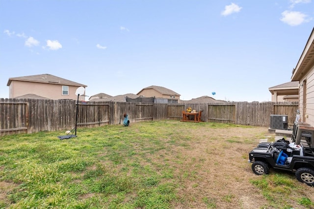 view of yard with a fenced backyard and central AC unit