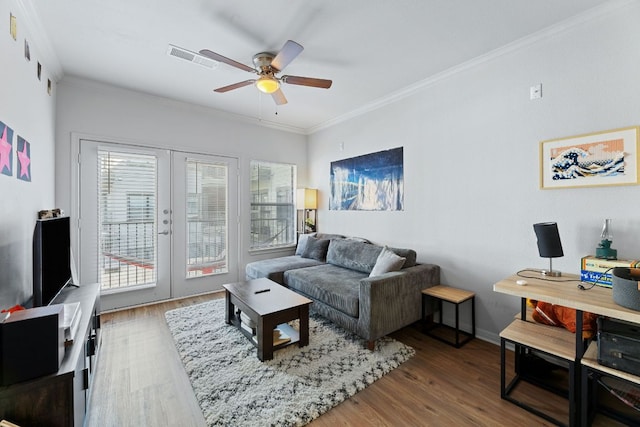 living room with wood finished floors, a ceiling fan, visible vents, french doors, and crown molding