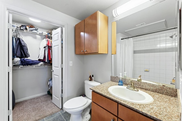 bathroom featuring curtained shower, toilet, vanity, visible vents, and a walk in closet