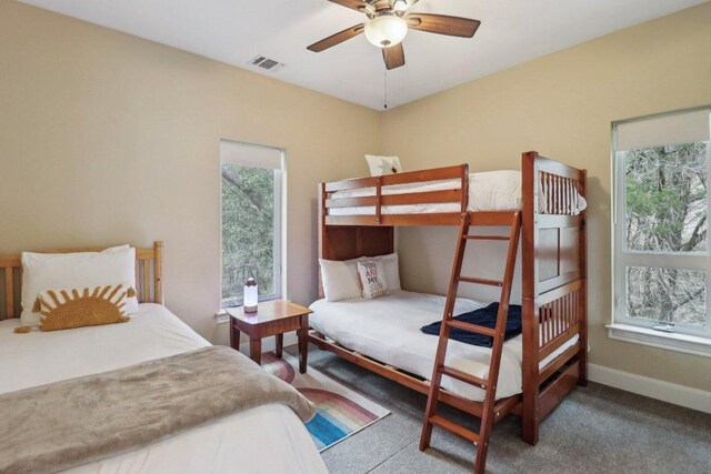 bedroom with carpet floors, visible vents, baseboards, and multiple windows