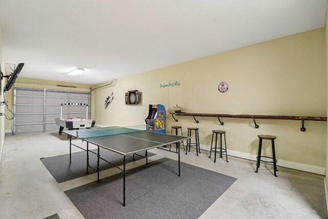 recreation room with a garage and concrete flooring