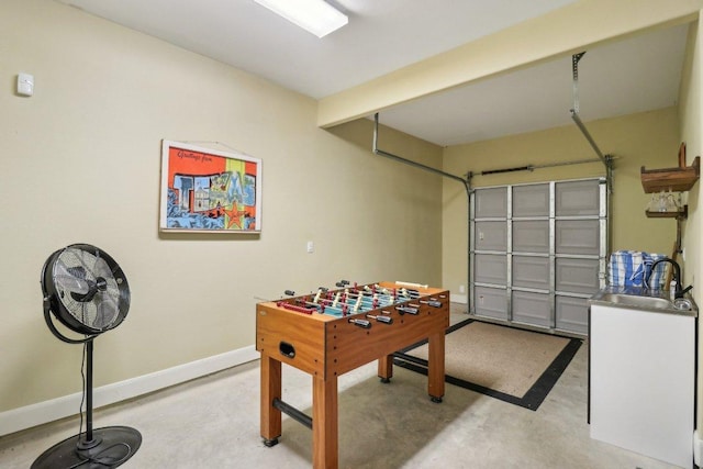 playroom with baseboards, concrete floors, and a sink