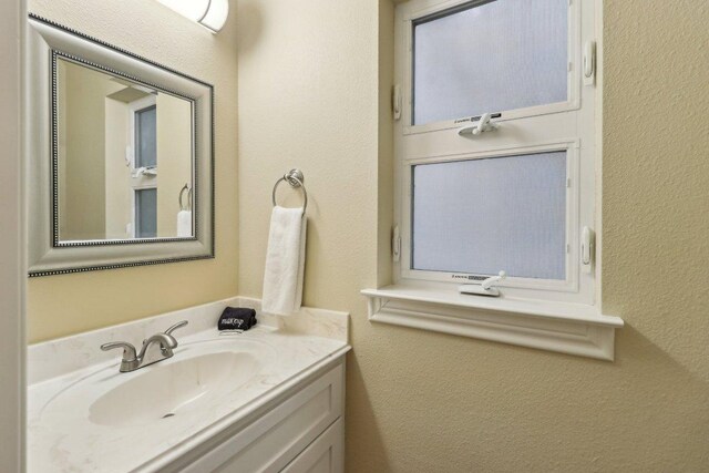 bathroom featuring a textured wall and vanity