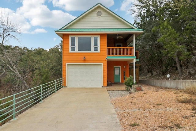 rustic home with a standing seam roof, metal roof, a garage, driveway, and a balcony