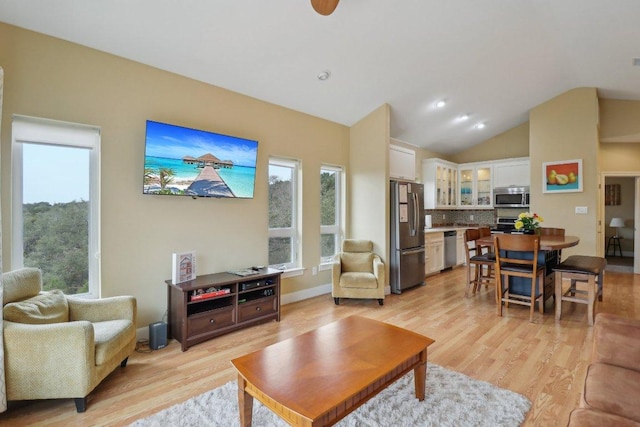 living area featuring light wood-type flooring and vaulted ceiling