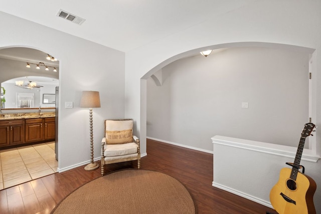 sitting room featuring light wood finished floors, visible vents, and baseboards