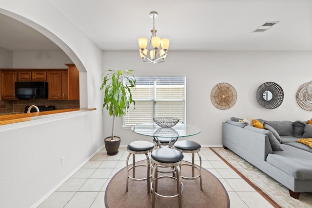 dining room featuring a chandelier, visible vents, baseboards, and light tile patterned floors