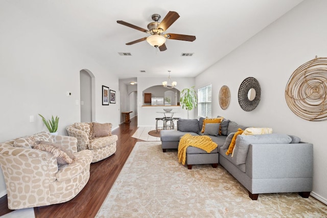 living room with a ceiling fan, arched walkways, visible vents, and wood finished floors