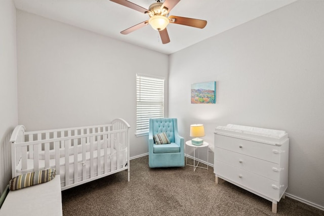 bedroom featuring carpet floors, a crib, baseboards, and a ceiling fan