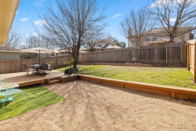 view of yard featuring outdoor dining area, a fenced backyard, and a wooden deck