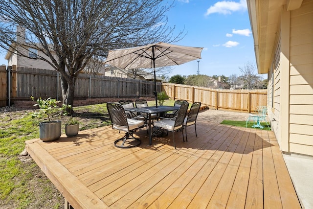 deck with outdoor dining space and a fenced backyard