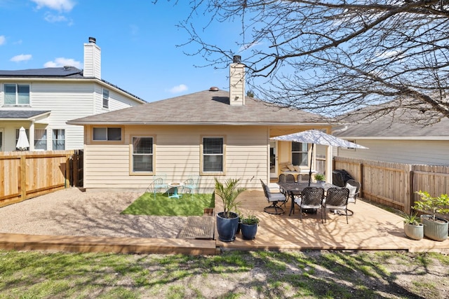 rear view of house featuring a fenced backyard and a deck