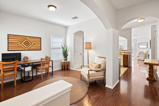 home office featuring visible vents, dark wood finished floors, and baseboards