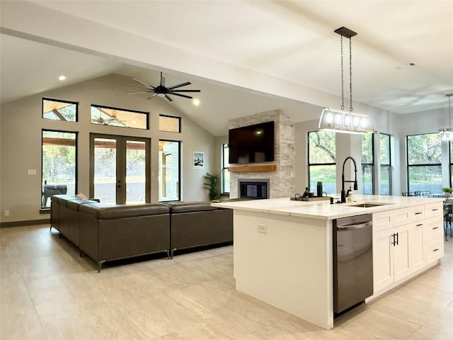 kitchen with a sink, white cabinetry, open floor plan, and stainless steel dishwasher