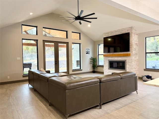 living area featuring french doors, a large fireplace, ceiling fan, high vaulted ceiling, and baseboards