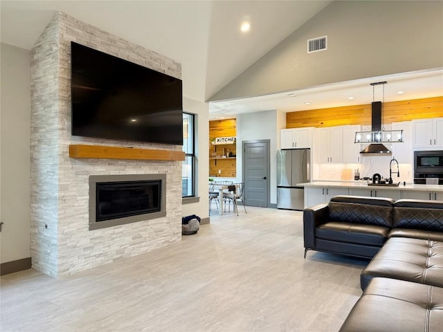 living room with high vaulted ceiling, recessed lighting, a fireplace, visible vents, and baseboards