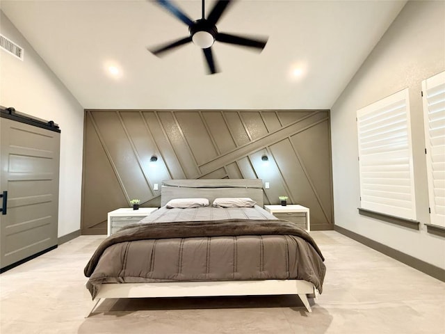 bedroom featuring vaulted ceiling, a barn door, visible vents, and baseboards