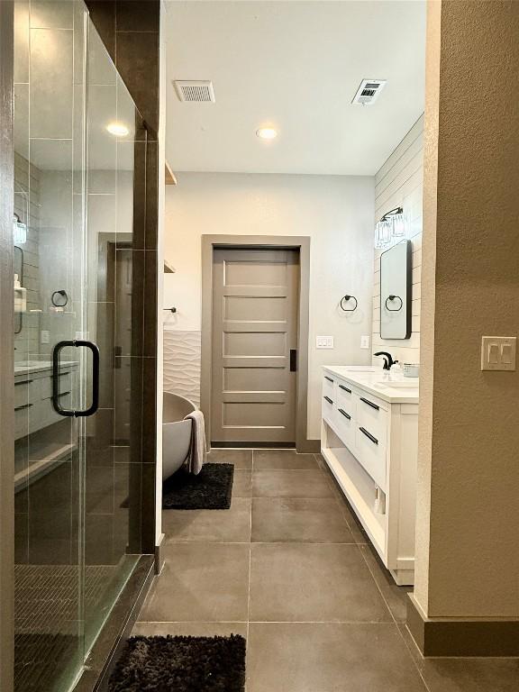 bathroom with visible vents, a stall shower, a freestanding tub, and vanity