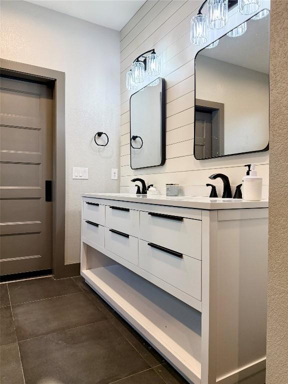 full bath with tile patterned flooring, a sink, and double vanity