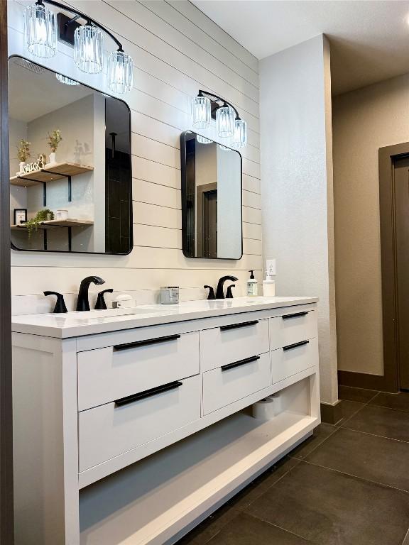 bathroom with tile patterned flooring, a sink, and double vanity