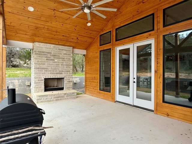 view of patio featuring an outdoor brick fireplace, french doors, and grilling area