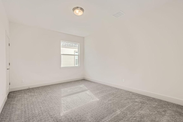 carpeted empty room featuring visible vents and baseboards