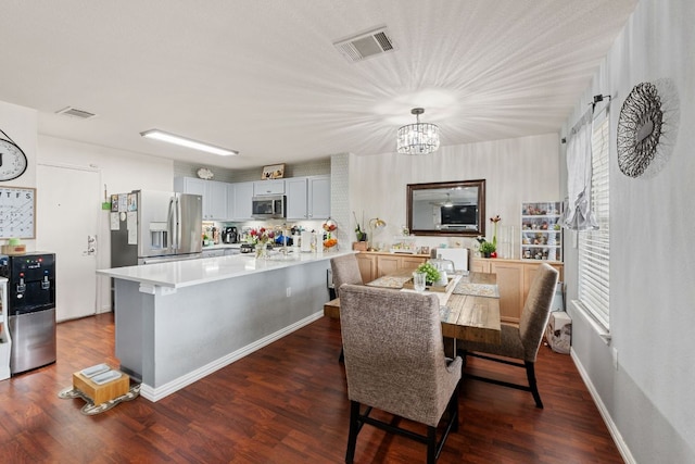 dining space with baseboards, visible vents, a chandelier, and dark wood-type flooring