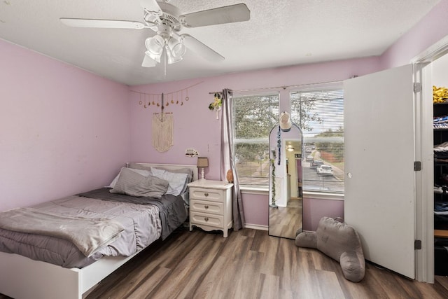 bedroom featuring a ceiling fan, a textured ceiling, and wood finished floors