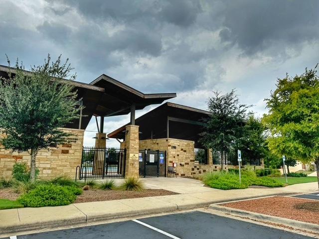 view of building exterior with uncovered parking and fence