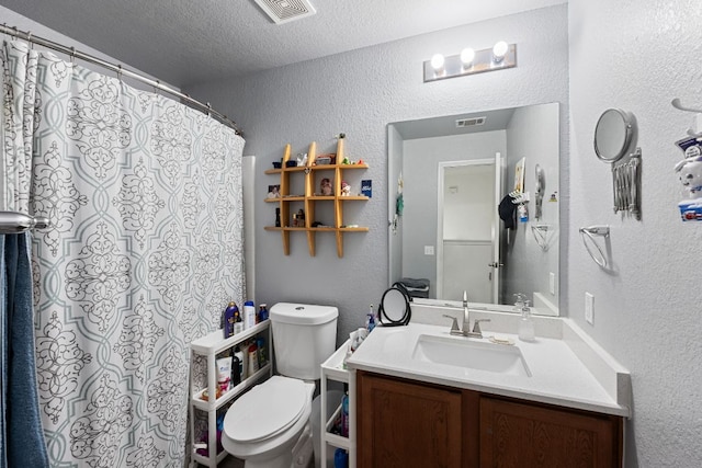 bathroom featuring visible vents, a textured wall, and a textured ceiling