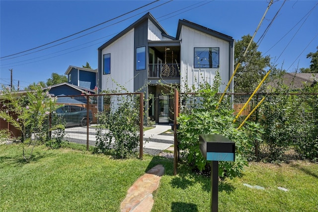 modern home featuring a front yard and fence