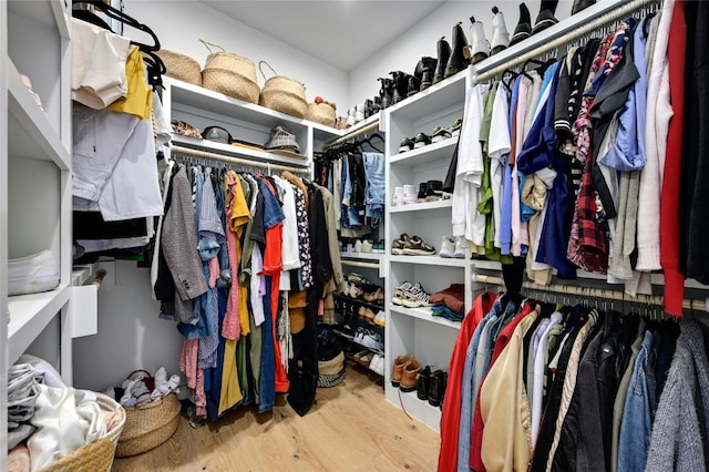 walk in closet with wood finished floors