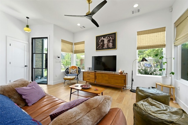 living area with recessed lighting, visible vents, and wood finished floors