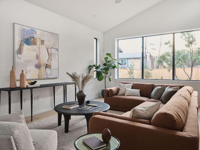 living room with baseboards, vaulted ceiling, and wood finished floors