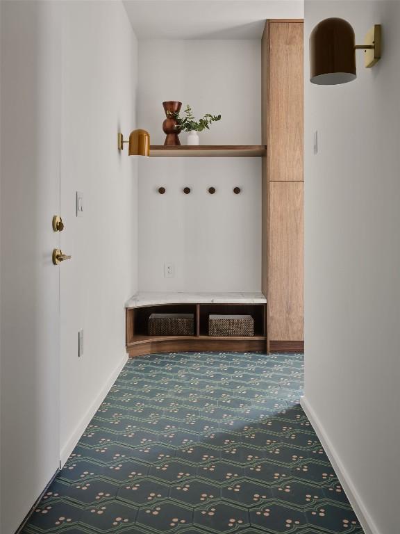 mudroom featuring carpet floors and baseboards