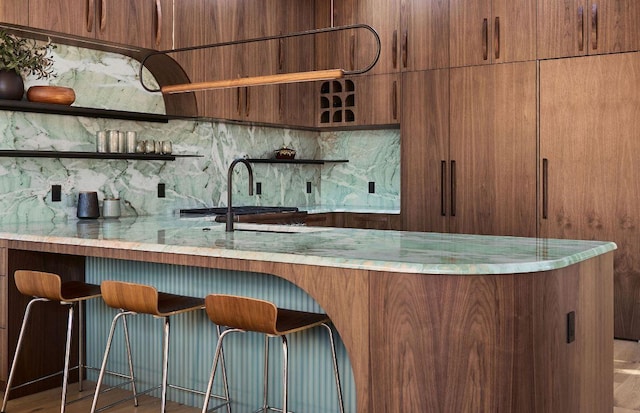 bar with decorative backsplash, a sink, and bar