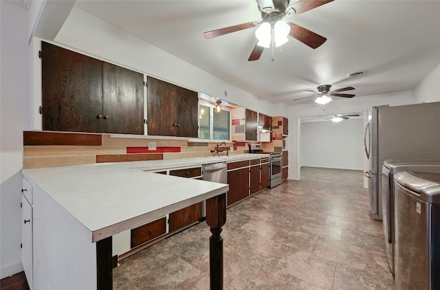 kitchen featuring dark brown cabinetry, appliances with stainless steel finishes, light countertops, washing machine and dryer, and a sink