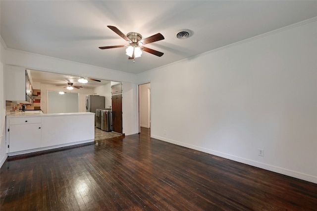 unfurnished living room featuring a sink, visible vents, baseboards, dark wood-style floors, and crown molding