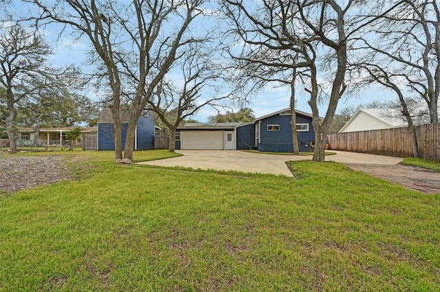 view of front of property featuring fence, driveway, a front lawn, and a patio