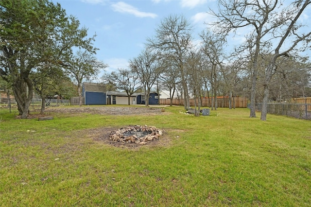 view of yard with fence and a fire pit