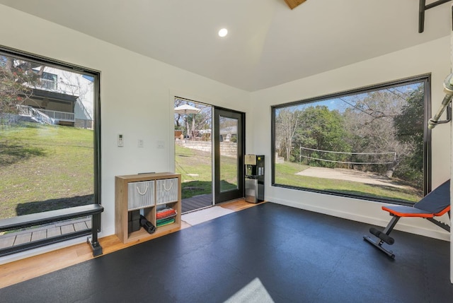 workout area featuring baseboards, a wealth of natural light, and recessed lighting