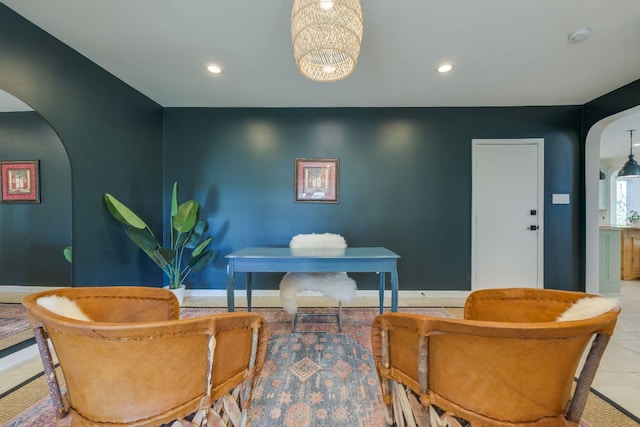 sitting room with arched walkways, baseboards, tile patterned flooring, and recessed lighting