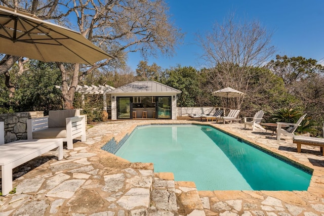 pool featuring a patio area, an outdoor structure, an exterior structure, and a pergola