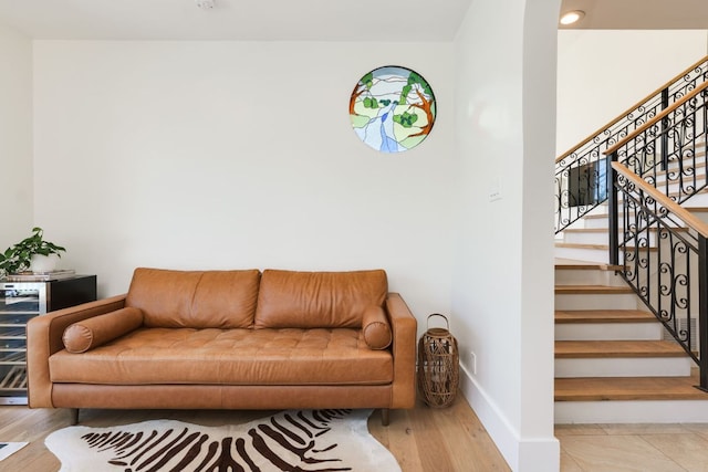 living room with stairs, baseboards, and wood finished floors