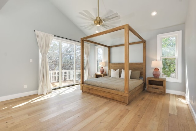 bedroom featuring lofted ceiling, access to outside, multiple windows, and light wood-style floors