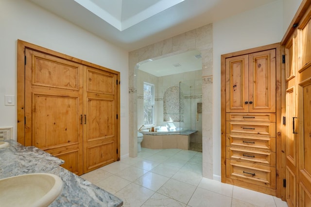 bathroom featuring a bath, toilet, walk in shower, and vanity