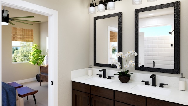 full bath featuring double vanity, baseboards, and a sink