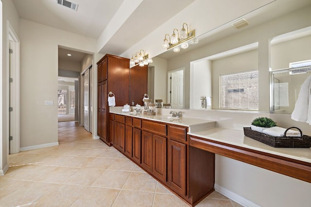 full bath featuring double vanity, visible vents, a sink, tile patterned flooring, and baseboards